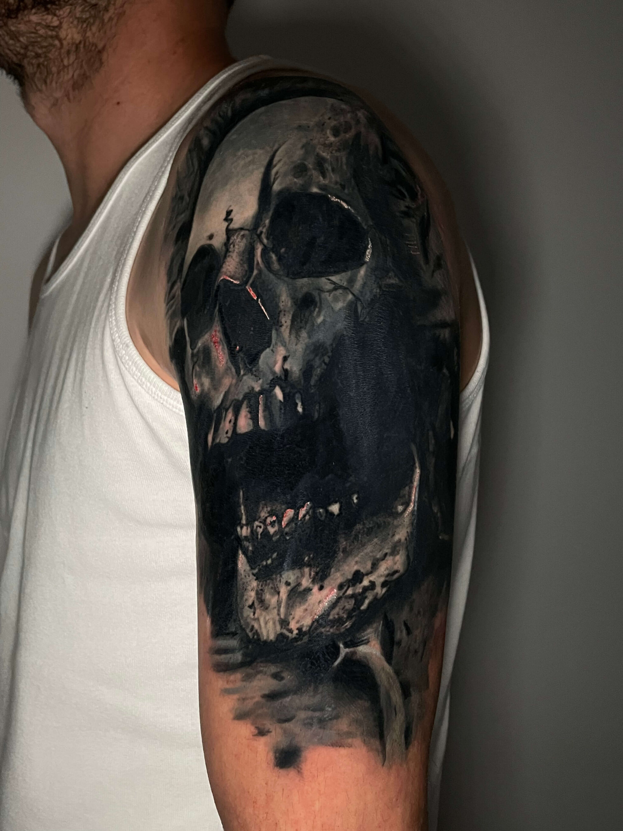 Schädel Cover-Up Tattoo Black and Grey Cover-Up Tattoo eines dunklen Schädels auf Schulter und Oberarm.