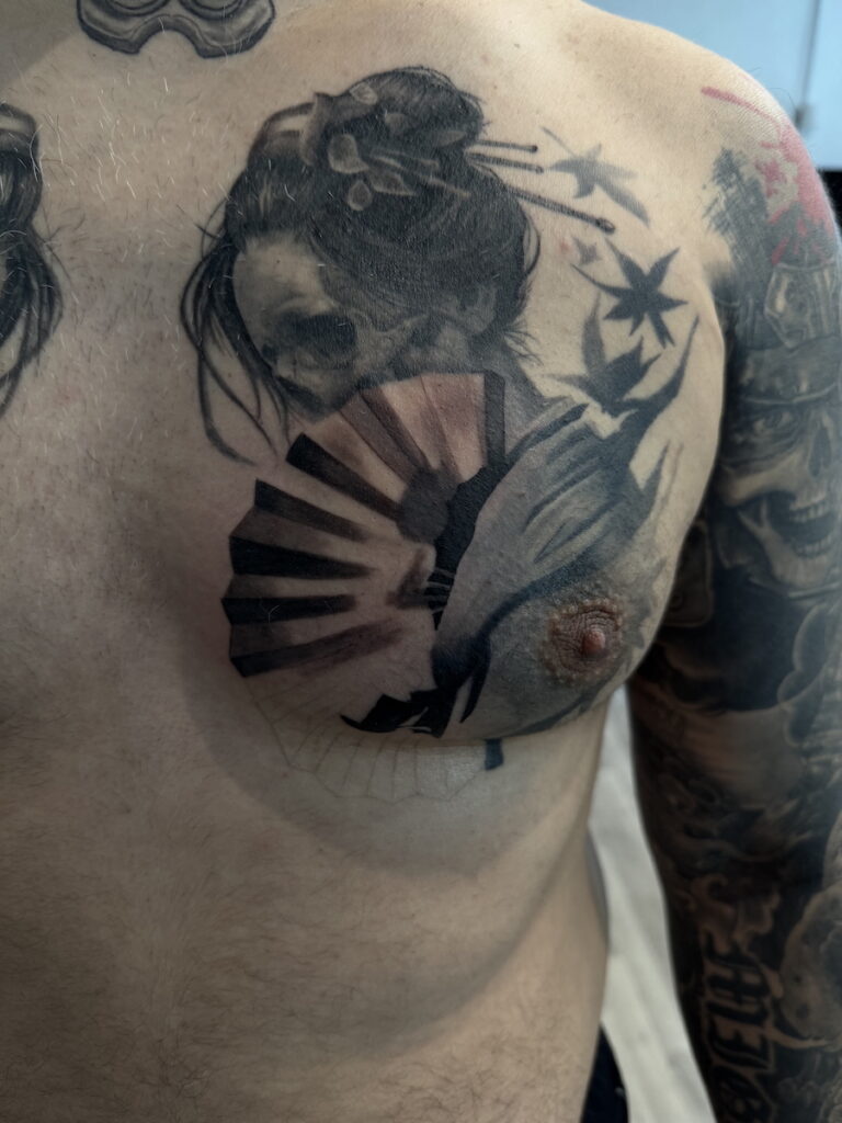 Black and Grey Brust Tattoo mit Porträt und deutlich sichtbarem Totenkopf